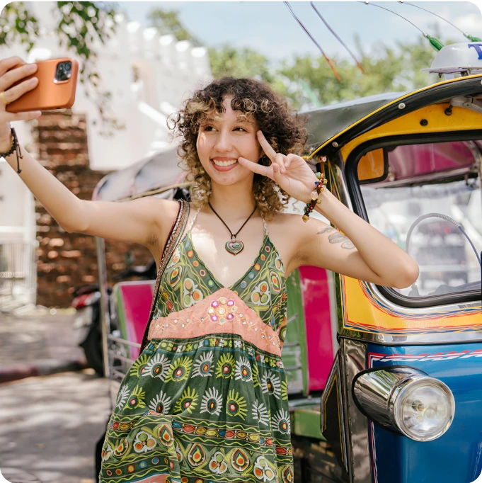 cheerful_young_woman_enjoying_travel_selfie_with_smartphone_near_tuk_tuk_weekend_3x